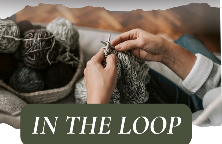 A close-up of hands knitting with yarn in a basket next to them. The words "IN THE LOOP" are overlaid on the image.