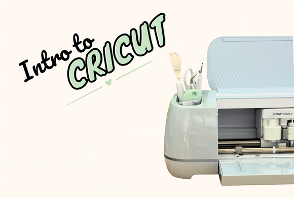 Open Cricut machine with tools inside, set on a light background. Text reads "Intro to Cricut" in bold letters, conveying a crafting theme.